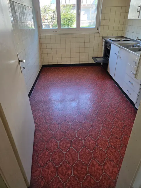Roter elastischer Bodenbelag in einer älteren Küche.