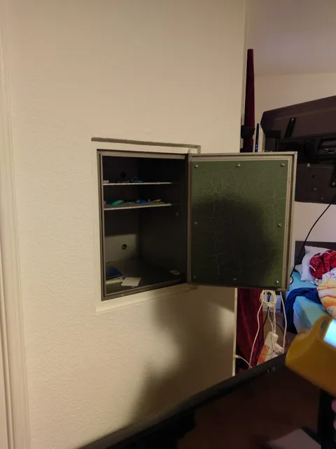 Älterer Einbautresor mit geöffneter Tür.