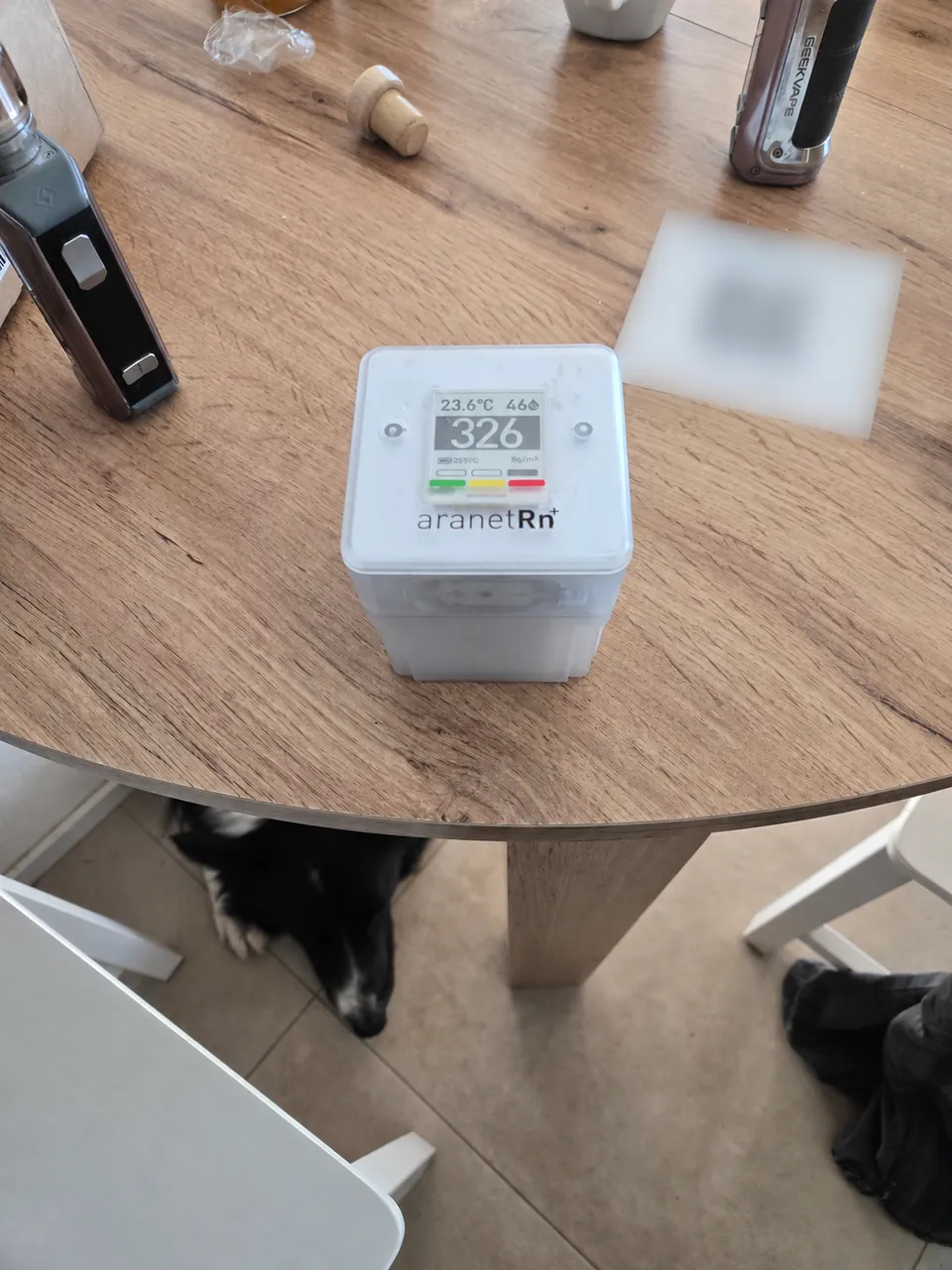 Radon detector on a table; document and QR code blurred.